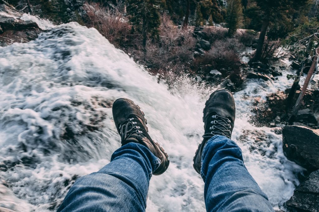 legs hanging off top of waterfall in Tahoe