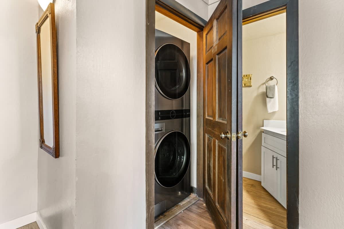 Laundry area with stacked machines in an Olympic Valley vacation rental, adjacent to a bathroom with a towel rack.