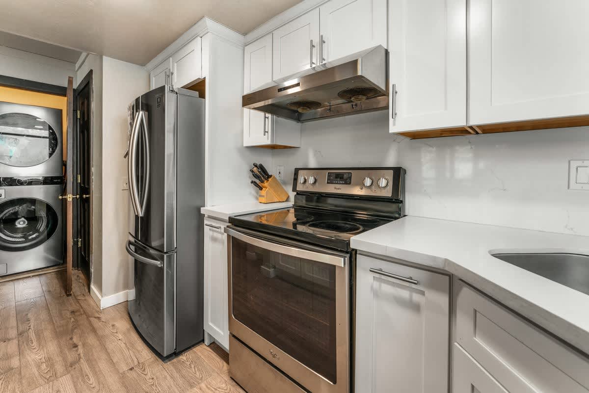 Modern kitchen in Olympic Valley vacation rental, featuring stainless steel appliances and in-unit washer and dryer.