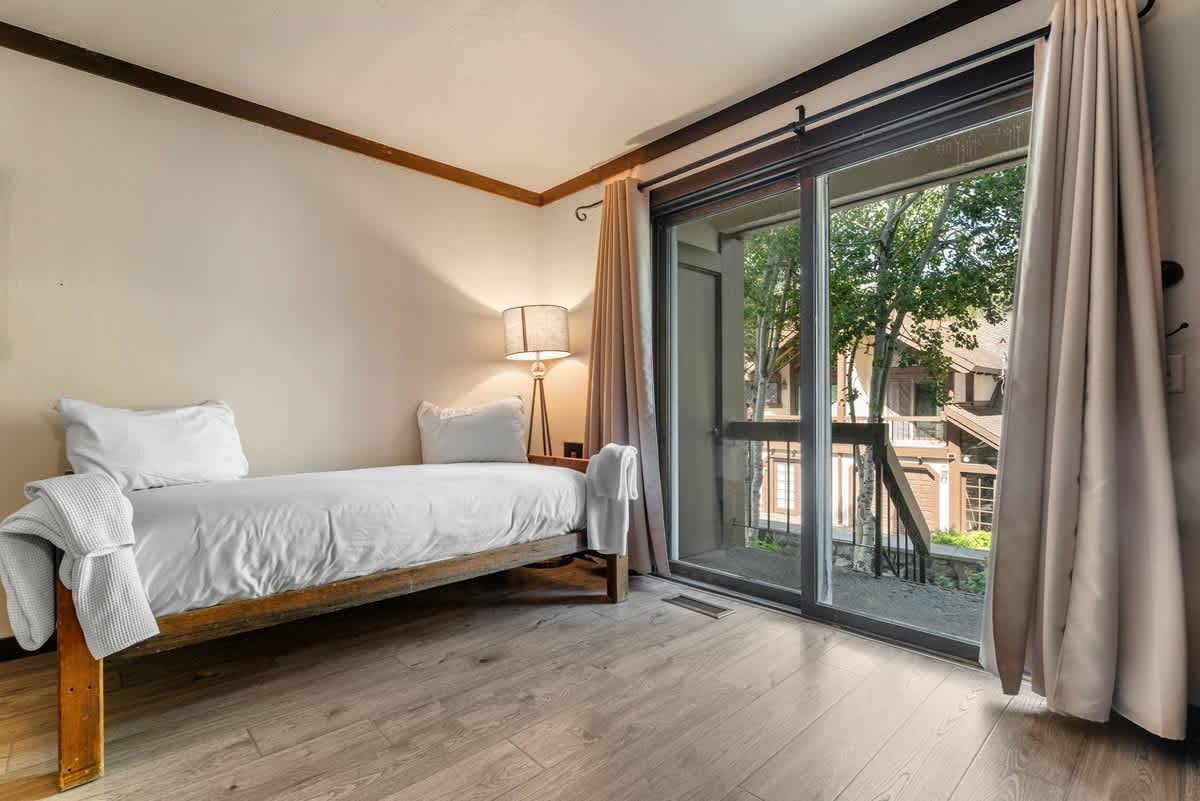 Cozy bedroom in Olympic Valley vacation rental with a large window and modern decor.