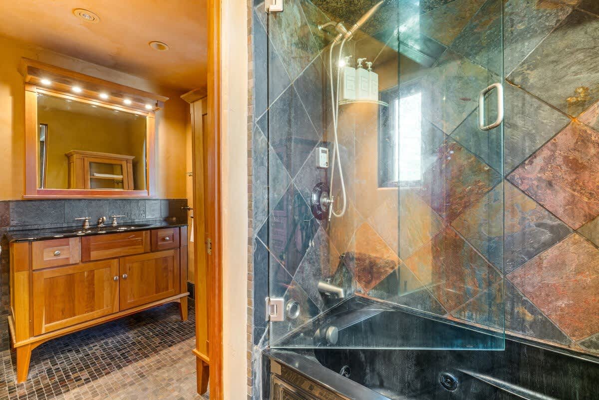 Luxury bathroom in Olympic Valley vacation rental with glass shower and wooden vanity.