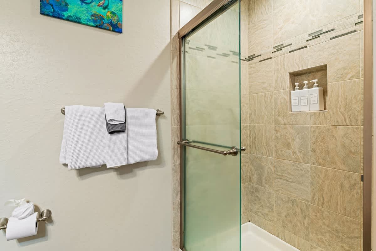 Modern bathroom in Tahoe City vacation rental with glass shower and neatly hung towels.