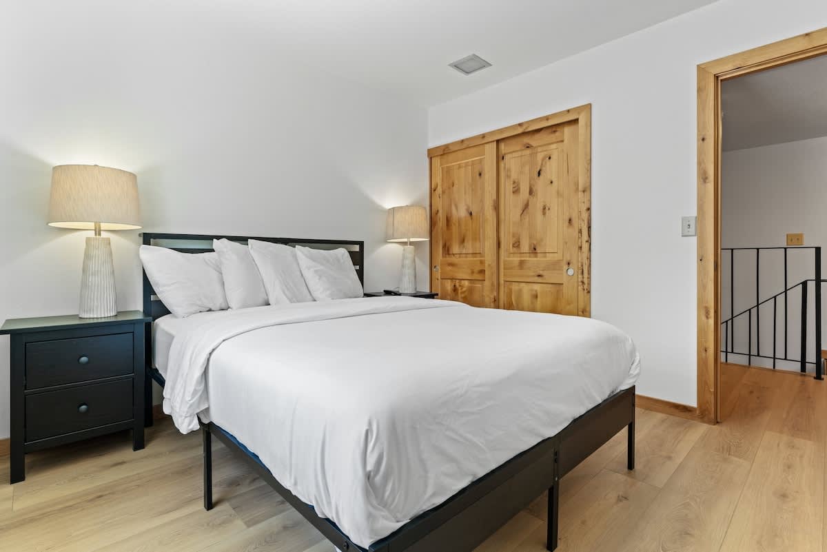 Cozy bedroom with a white bed and wooden decor in a Tahoe City vacation rental.