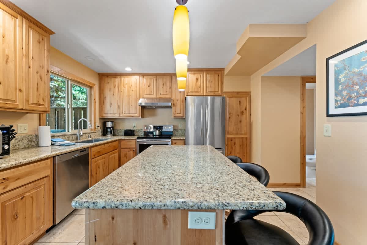 Modern kitchen in a Tahoe City vacation rental with wood cabinets, granite countertops, and stainless steel appliances.