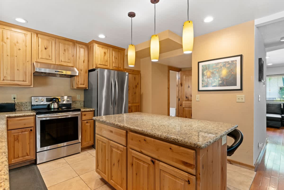 Modern kitchen with wooden cabinets and granite island in a Tahoe City vacation rental.