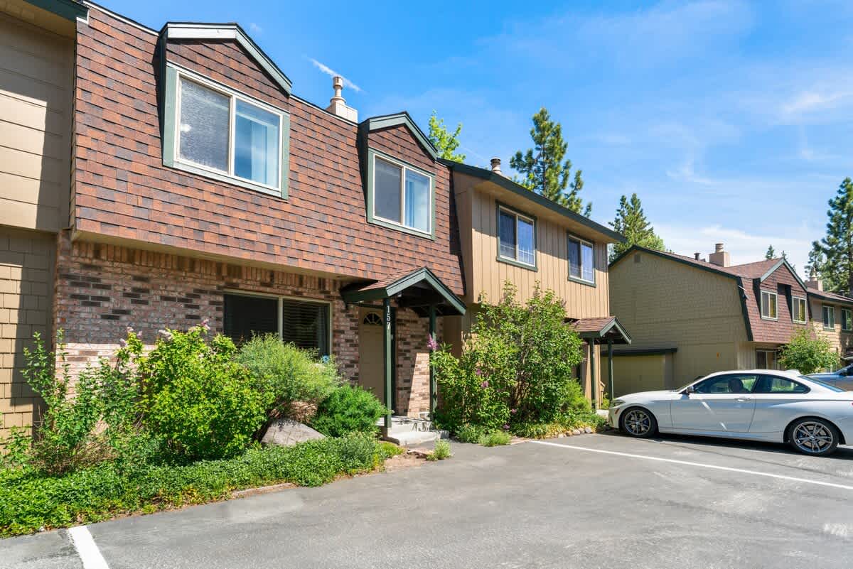 Townhouse in Tahoe City, perfect for a vacation rental, with a car parked in front and greenery surrounding the entrance.