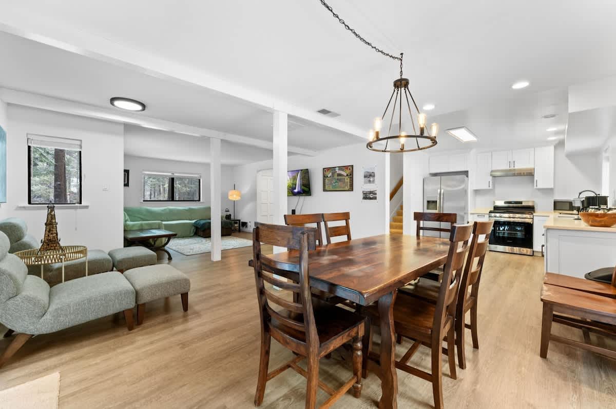 Modern open-plan living area in a Truckee vacation rental, featuring a dining table, kitchen, and cozy seating.