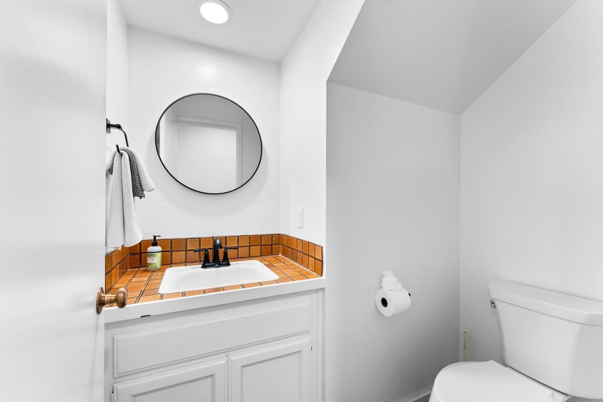 White bathroom with orange tile accents in a Truckee vacation rental.