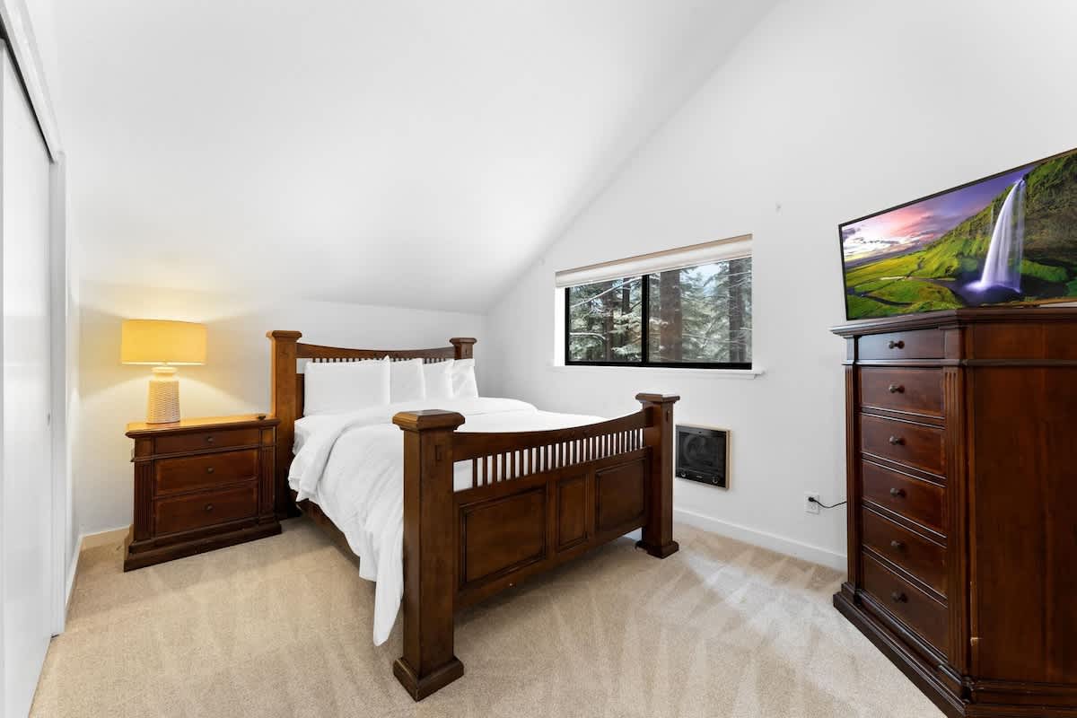 Cozy bedroom with wooden furniture and forest view in Truckee vacation rental.