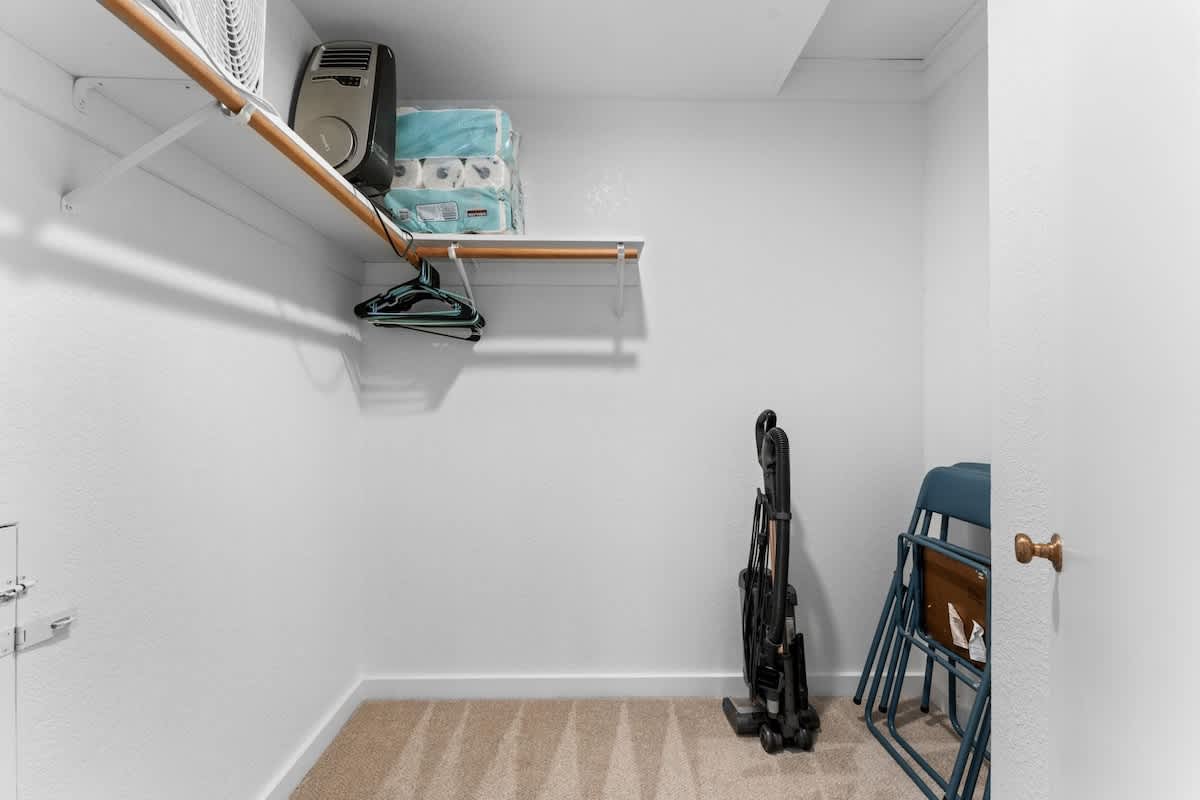 Closet in a Truckee vacation rental with hangers, vacuum, folding chairs, and shelves holding a heater and paper towels.