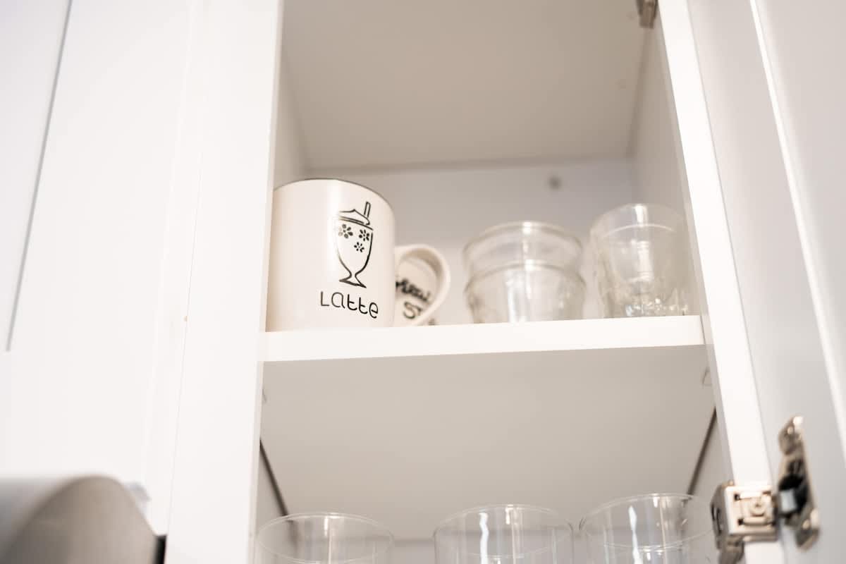 Kitchen cabinet with clean mugs and glasses in a Truckee vacation rental.