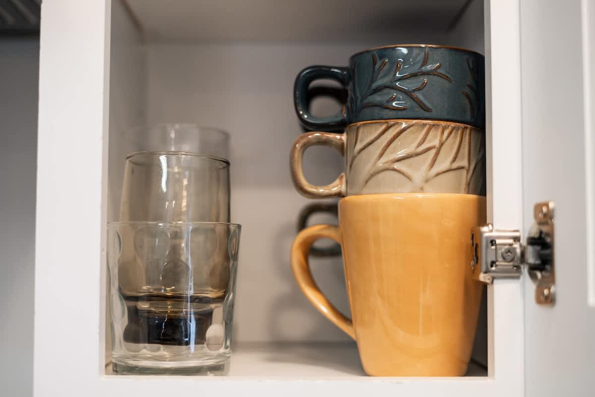 Mugs and glasses neatly arranged in a kitchen cabinet of a Truckee vacation rental.