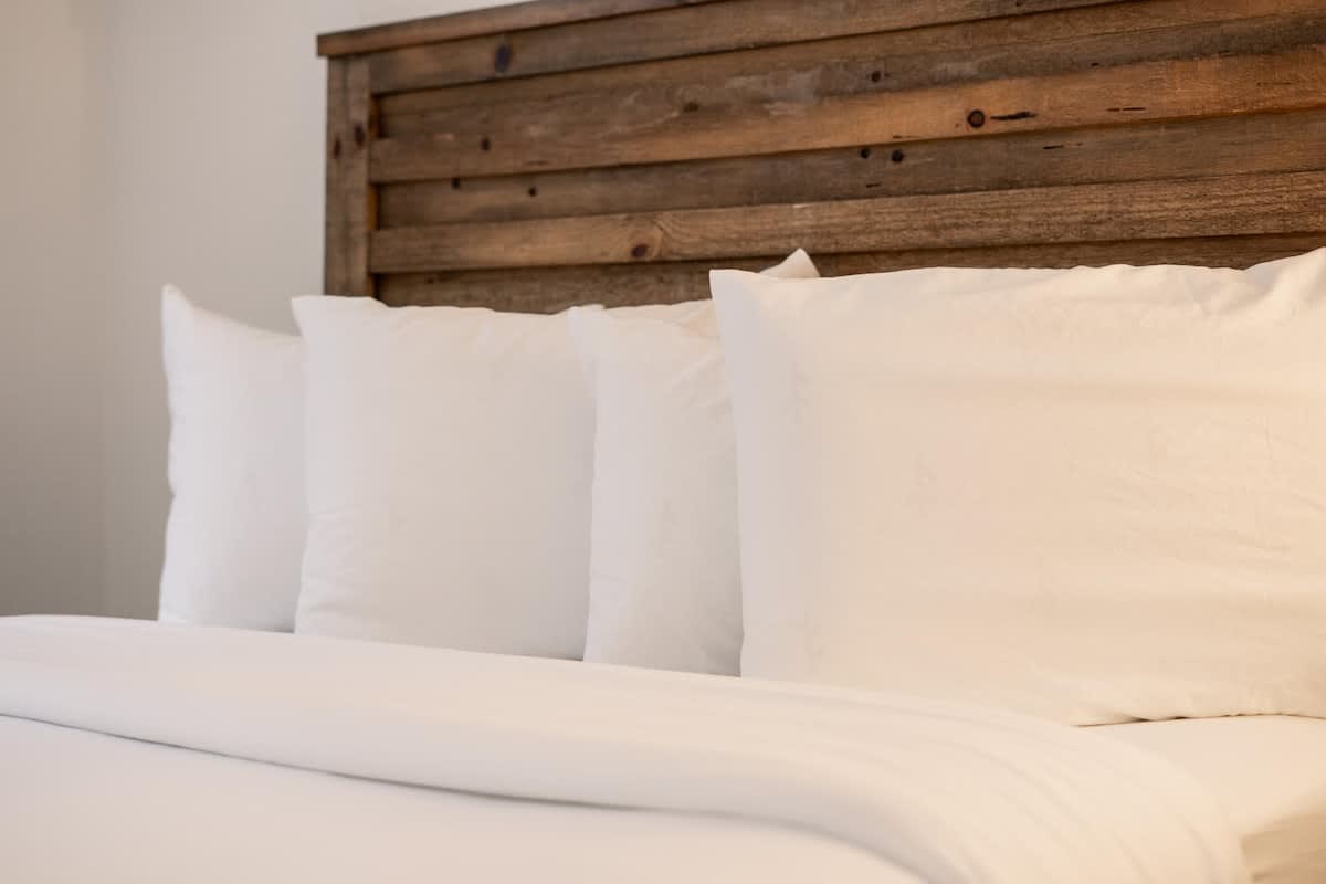 Cozy bedroom with clean white pillows and wooden headboard in a Truckee vacation rental.