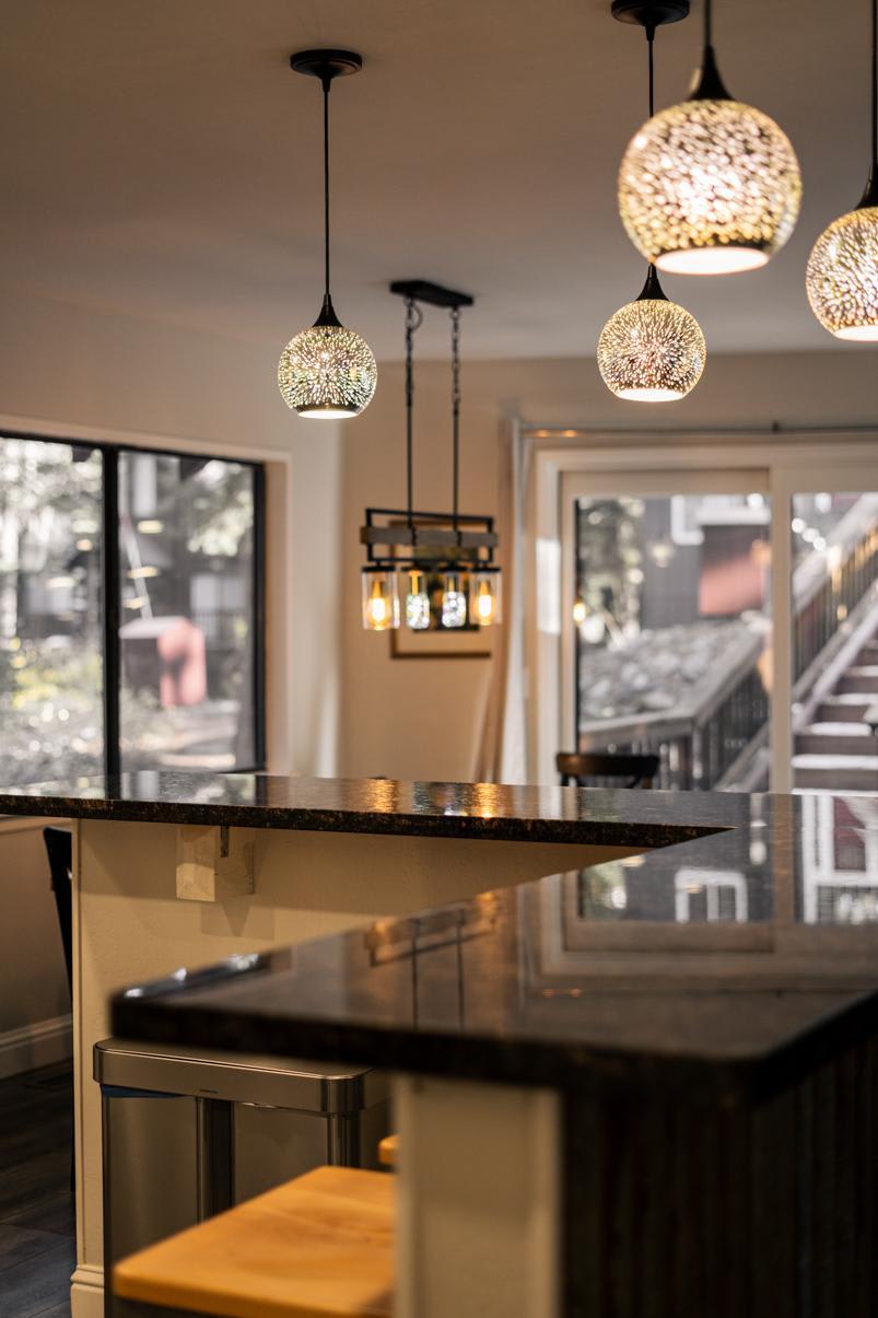 Modern kitchen interior with elegant lighting in a Tahoe Vista vacation rental. Large windows and stylish countertops visible.