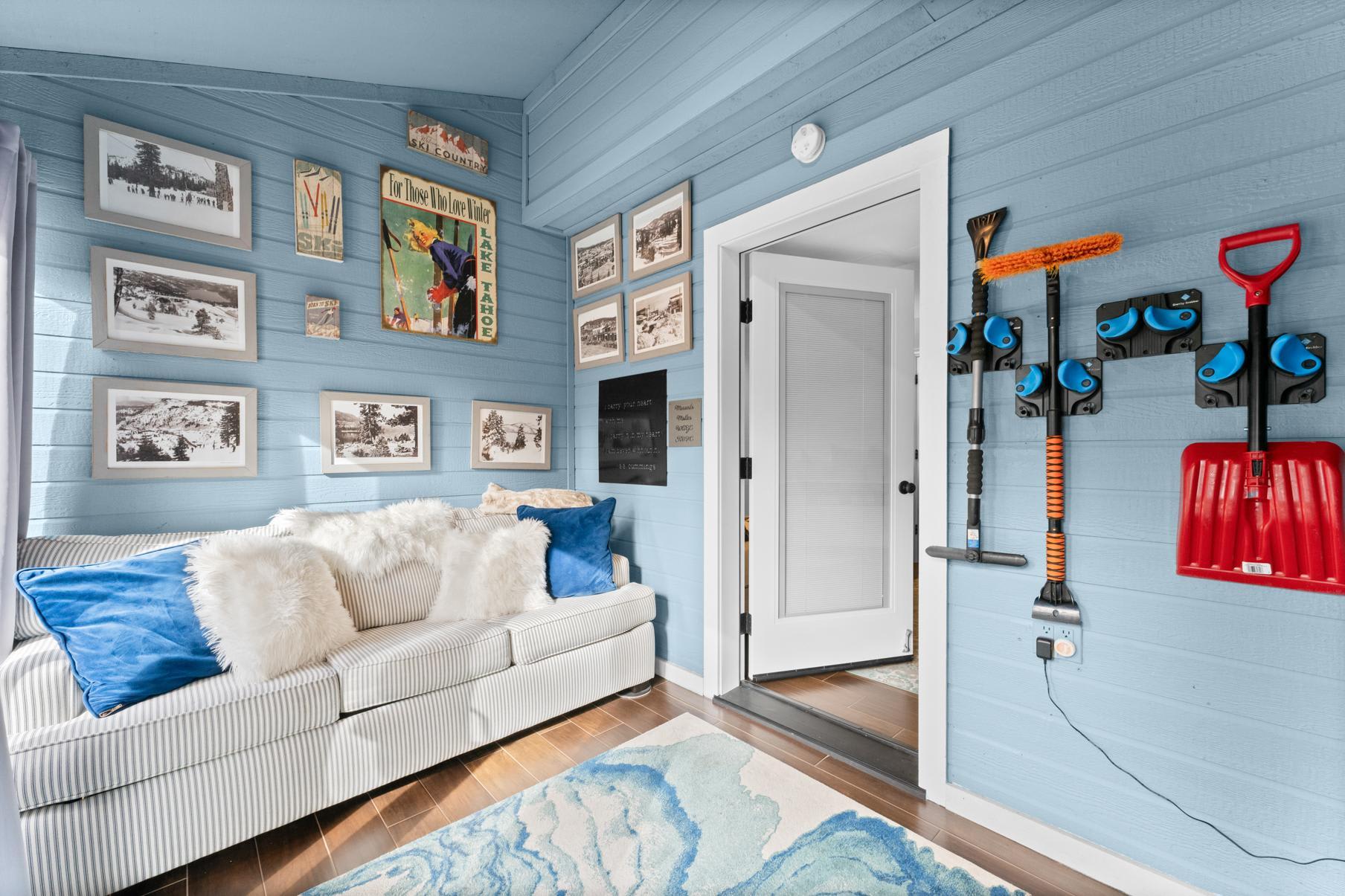 Cozy Truckee vacation rental with a striped sofa, fluffy pillows, and ski decor on blue walls.