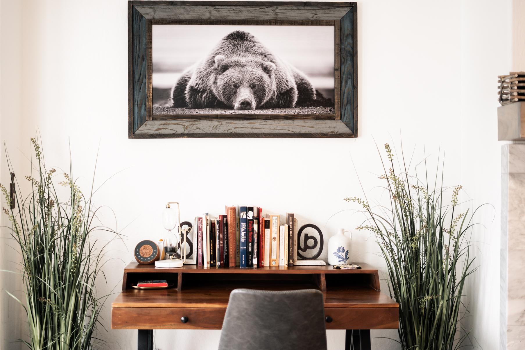 Cozy desk with books and decor in a Truckee vacation rental, featuring a framed bear photograph.