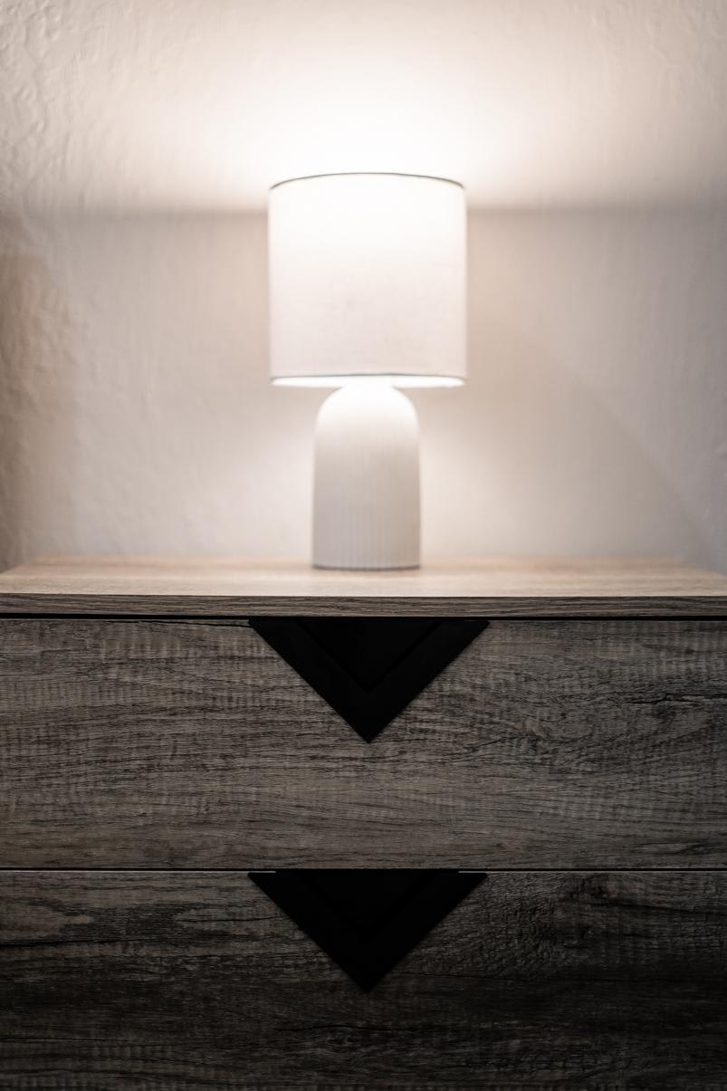 Rustic wooden dresser with a glowing lamp in Truckee vacation rental.