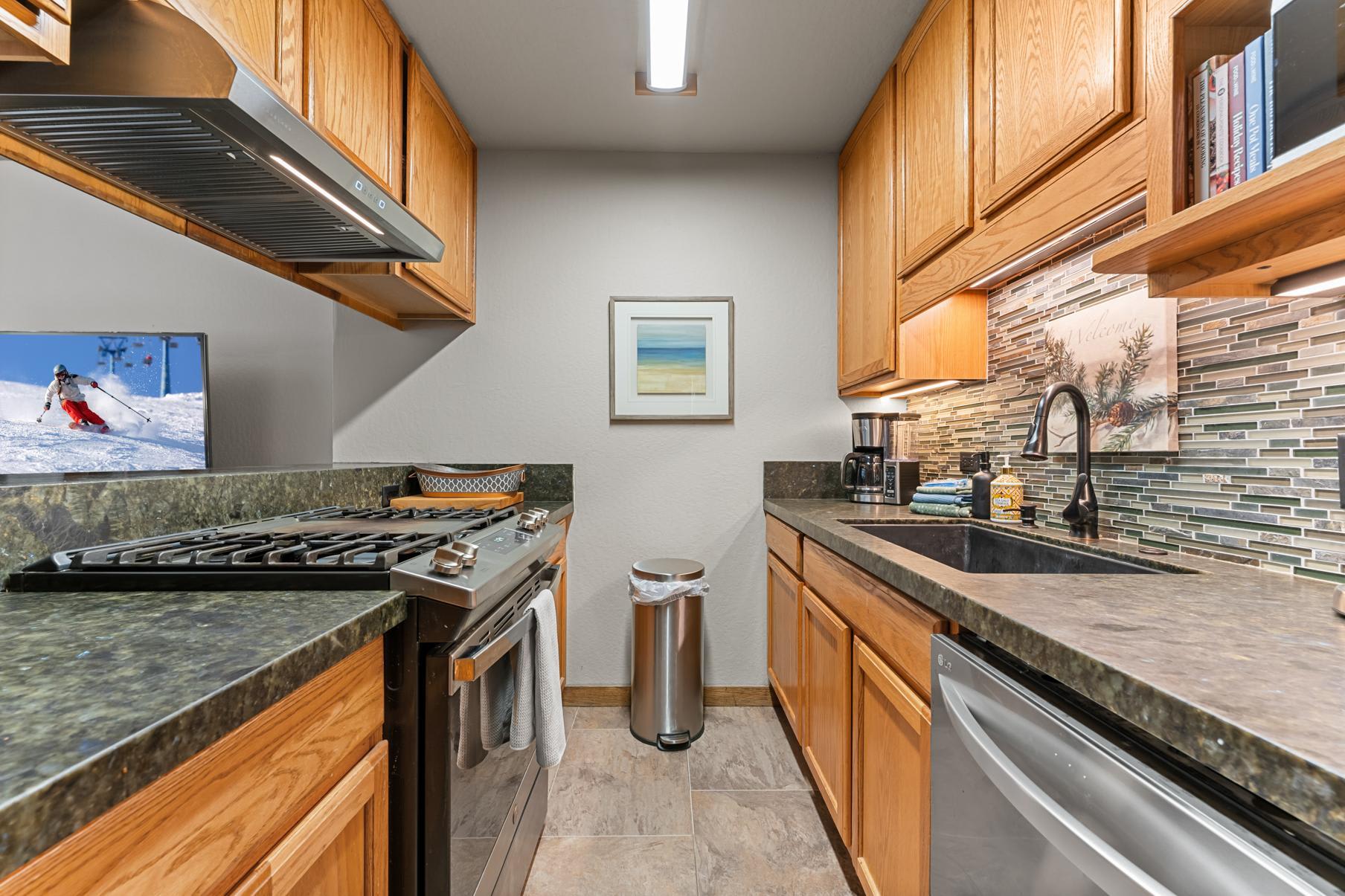 Modern kitchen in a Truckee vacation rental with wooden cabinets, stove, and sink.