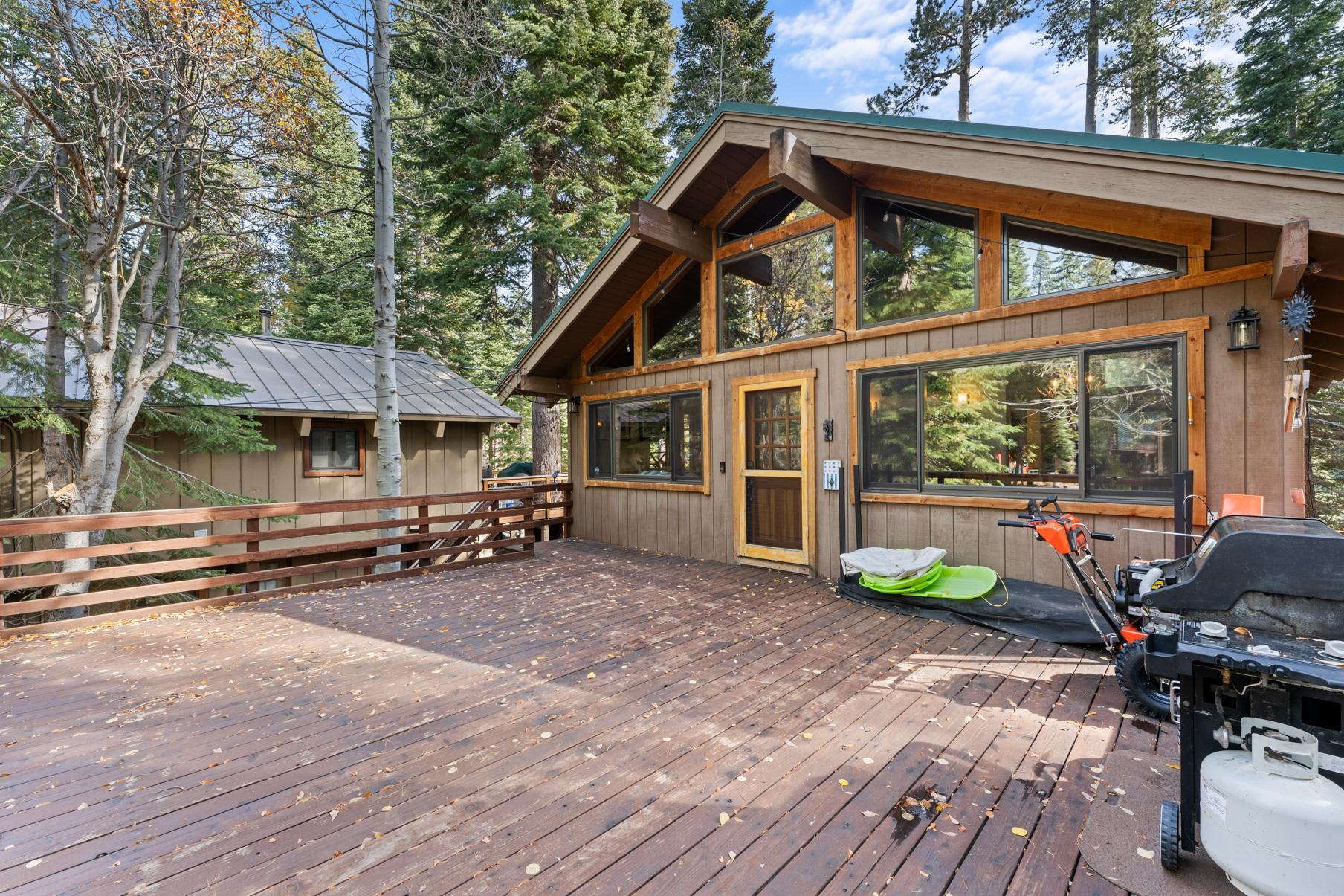 Wooden deck of a cozy cabin surrounded by tall trees in Truckee, perfect for a vacation rental getaway.