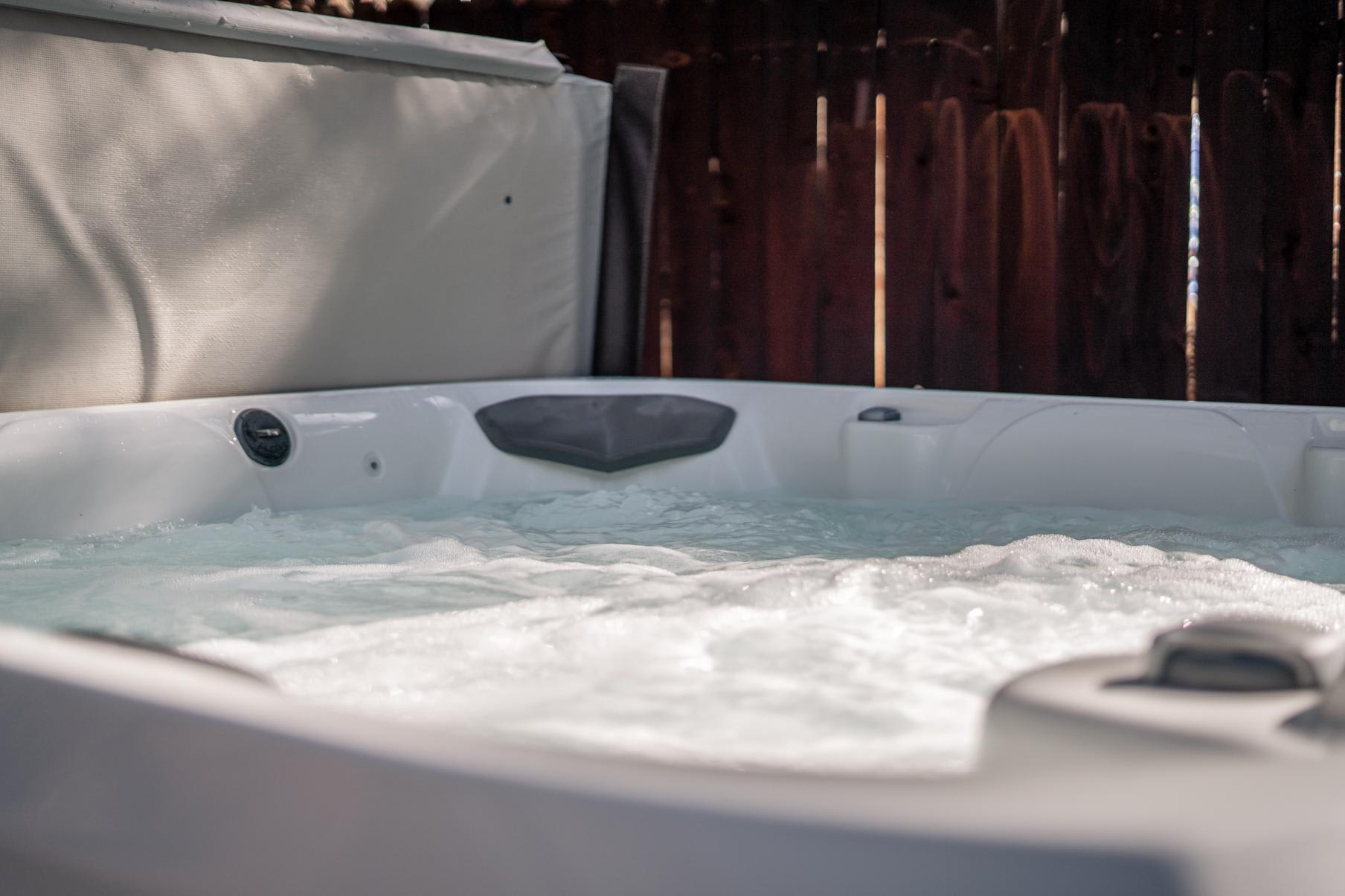 Outdoor hot tub at a Truckee vacation rental, surrounded by a wooden fence, offering a relaxing experience.