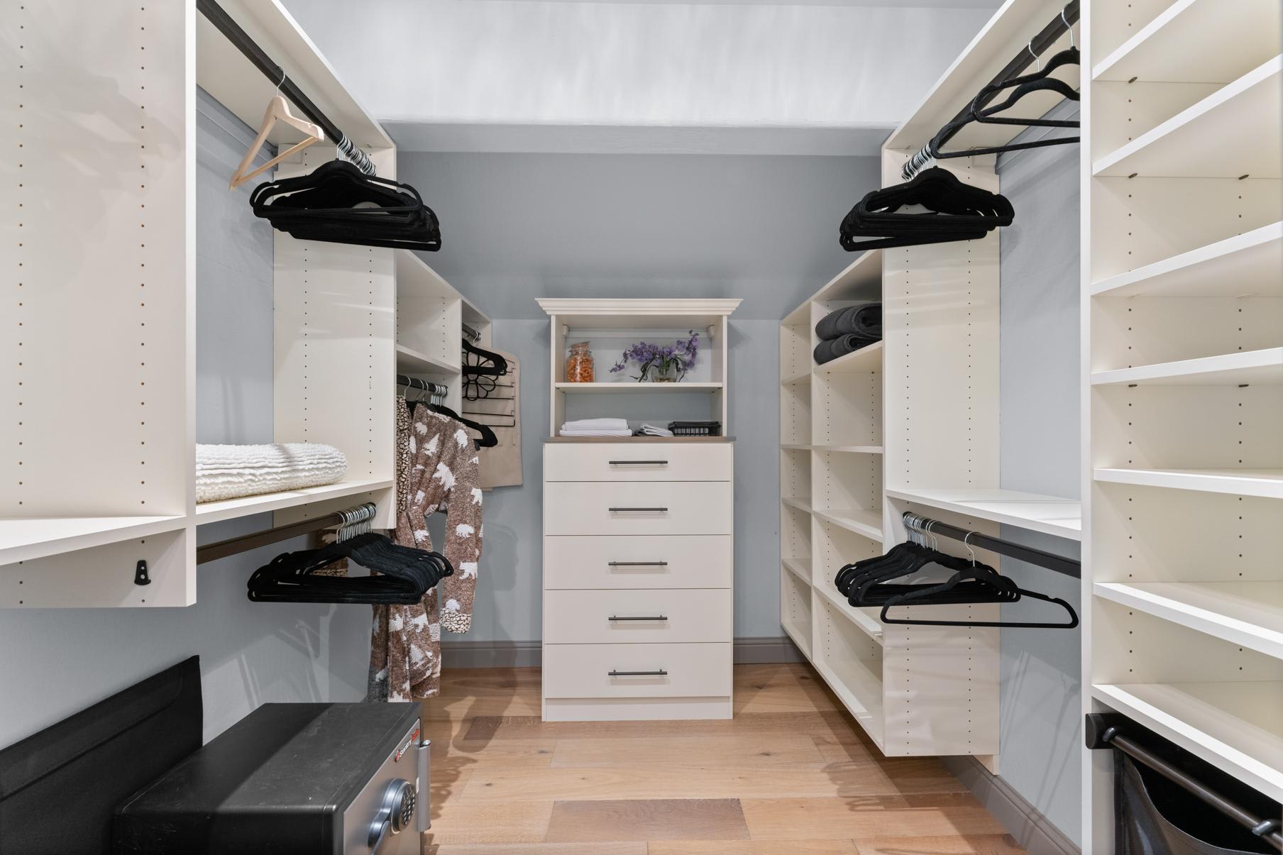 Spacious walk-in closet in a Truckee vacation rental, featuring white shelving and drawers with neatly arranged hangers.