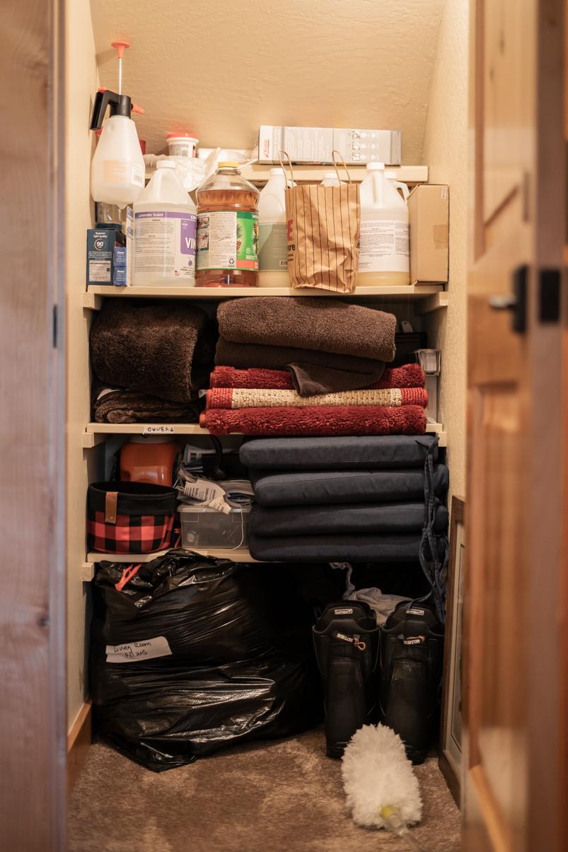 Closet in Truckee vacation rental filled with cleaning supplies, towels, folded linens, and storage bags.