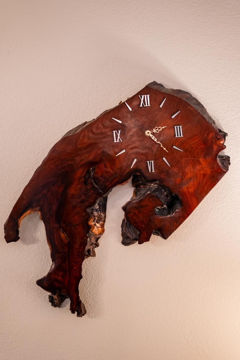 Rustic wooden clock with Roman numerals on a wall in Truckee vacation rental.