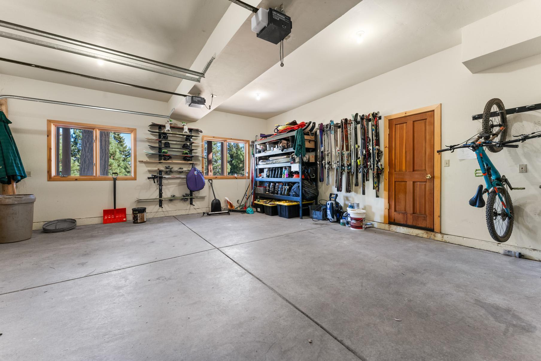 Spacious garage in a Truckee vacation rental with ski gear and a bike mounted on the wall.