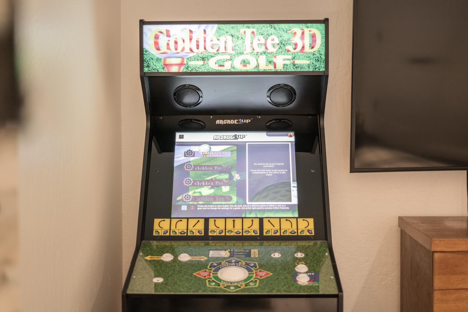 Arcade game in a Truckee vacation rental, featuring Golden Tee 3D Golf machine next to a wooden cabinet.