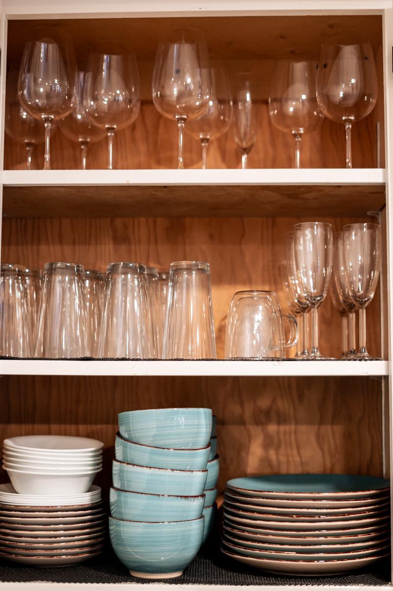 Wine glasses and stacked dishes in a Tahoe Vista vacation rental kitchen cabinet.