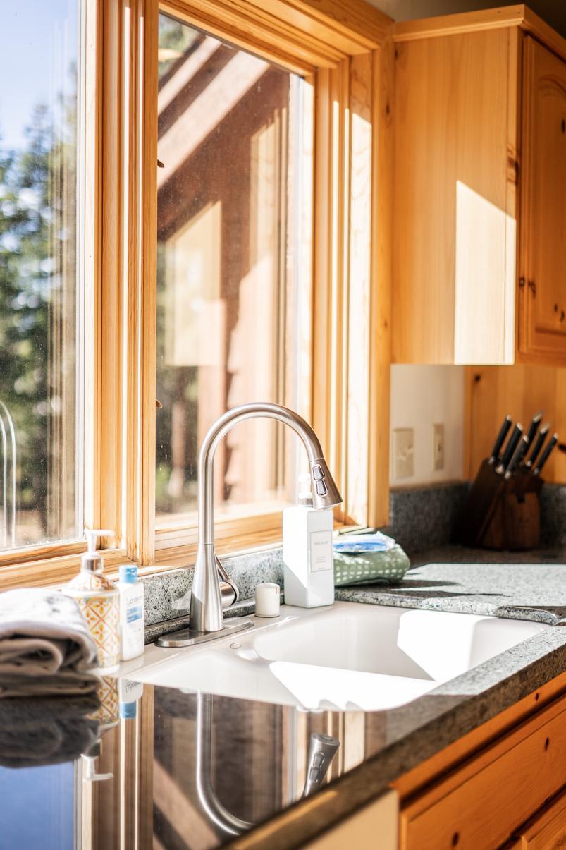 Sunny kitchen with wooden cabinets in a Truckee vacation rental, featuring a modern sink and countertop essentials.