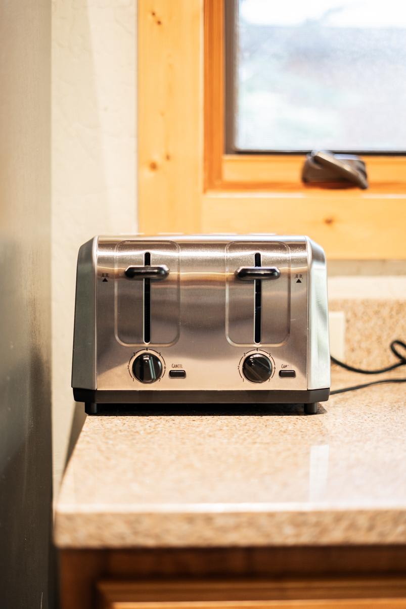 Stainless steel toaster on a kitchen counter in a Truckee vacation rental. Light streaming through a nearby window.