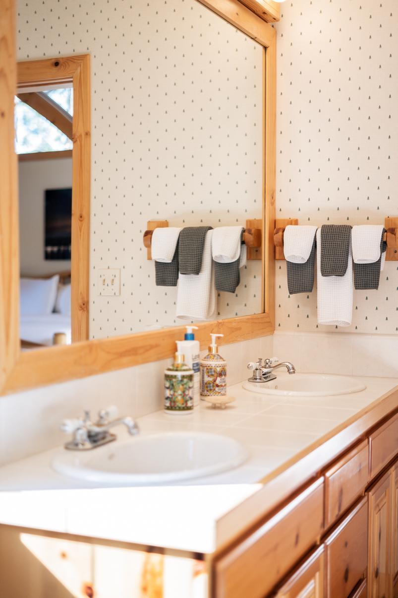 Dual sinks with elegant decor in a Truckee vacation rental bathroom with wooden accents and stylish toiletries.