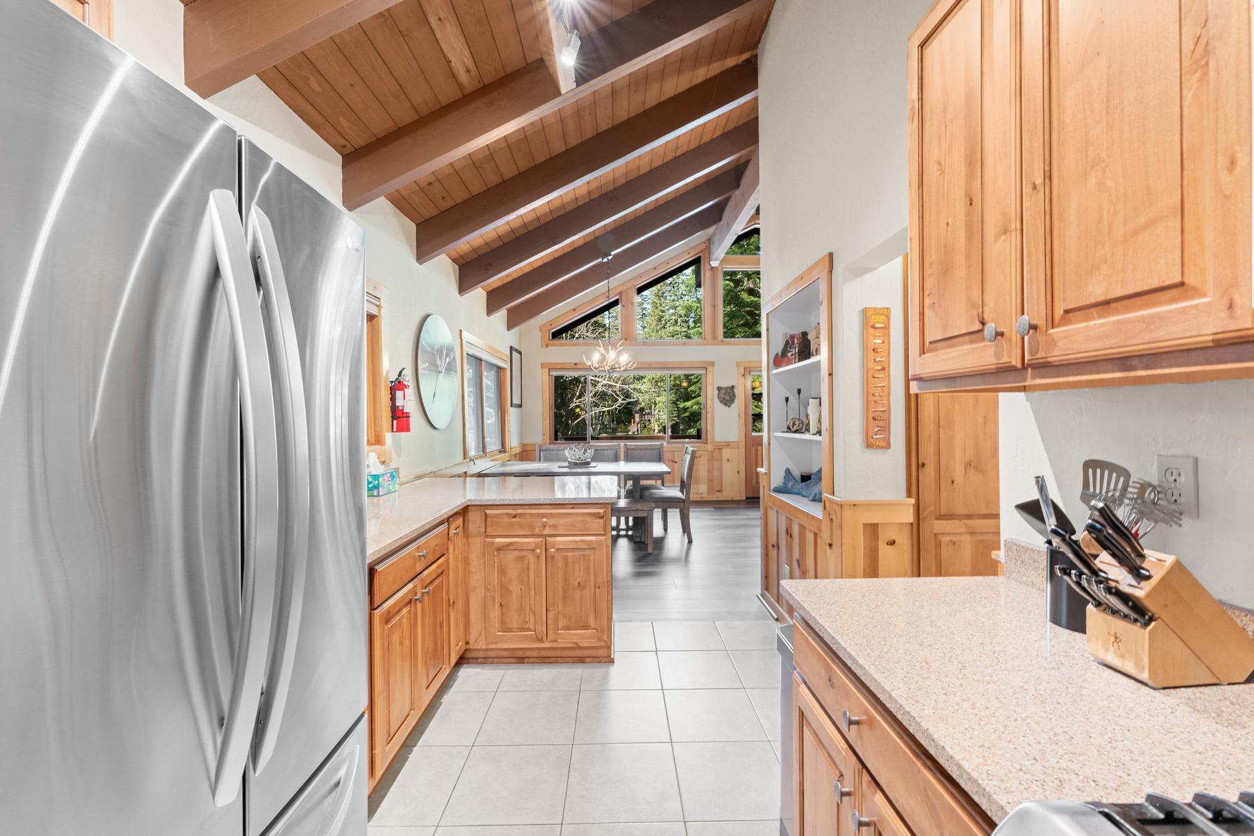 Spacious kitchen in a Truckee vacation rental with wooden cabinets, stainless steel appliances, and large windows.