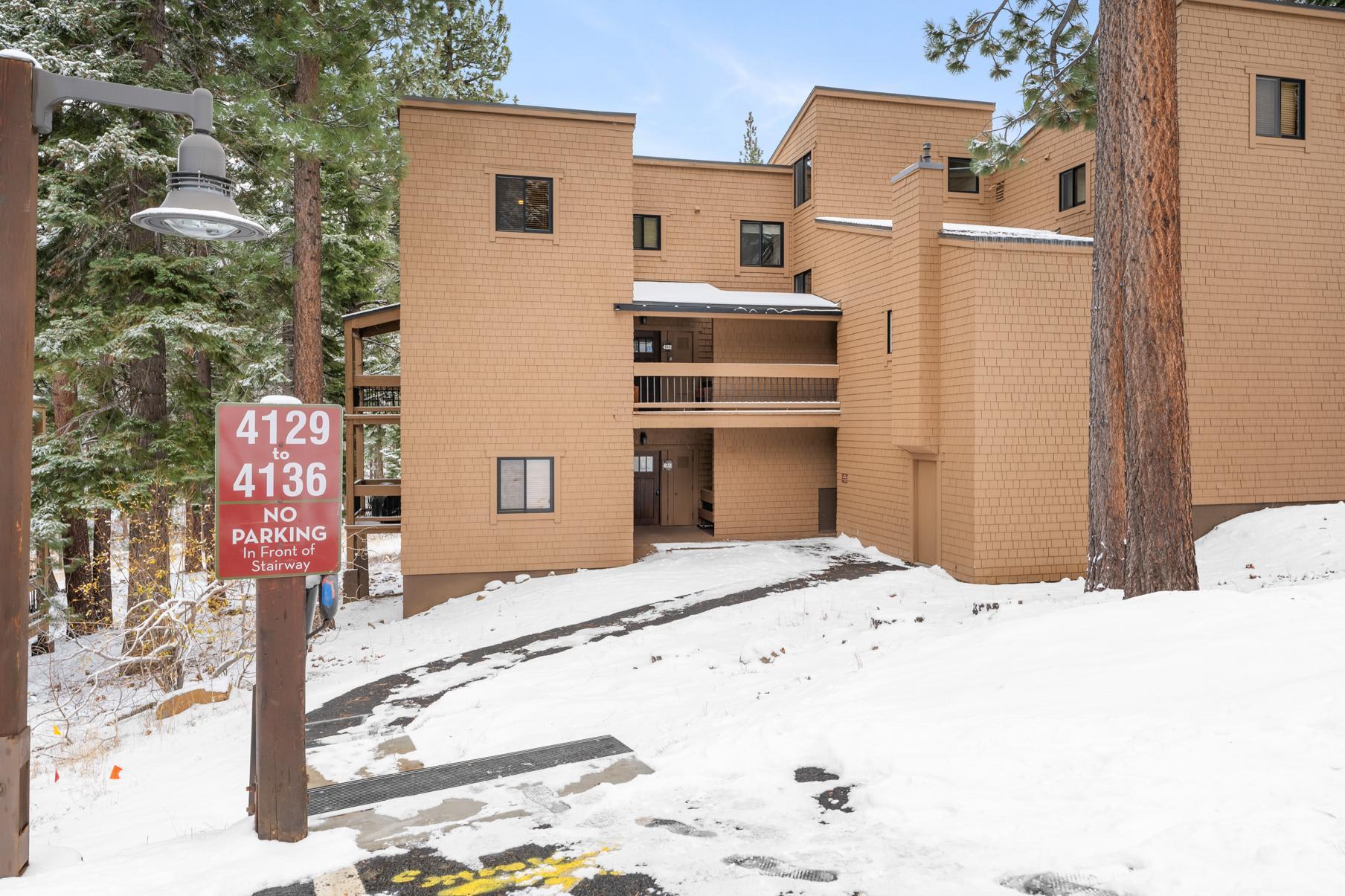 Brown building in snowy Truckee forest, labeled 4129 to 4136, serves as a cozy vacation rental.