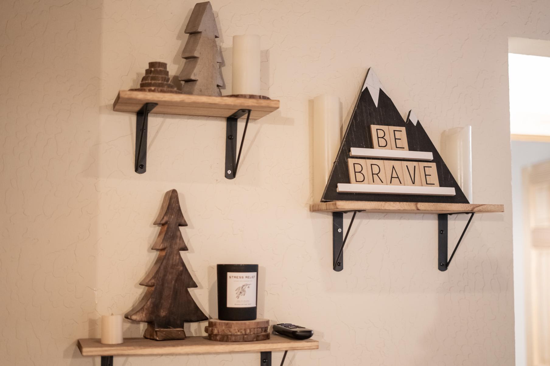 Decorative wooden shelves with trees and a "Be Brave" sign in a Truckee vacation rental.