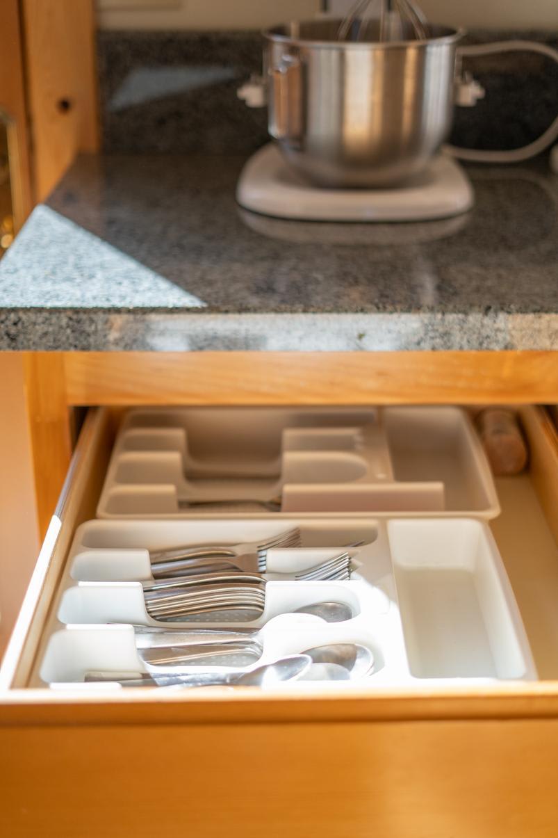 Open kitchen drawer with cutlery, granite countertop, and a mixer in a Truckee vacation rental.