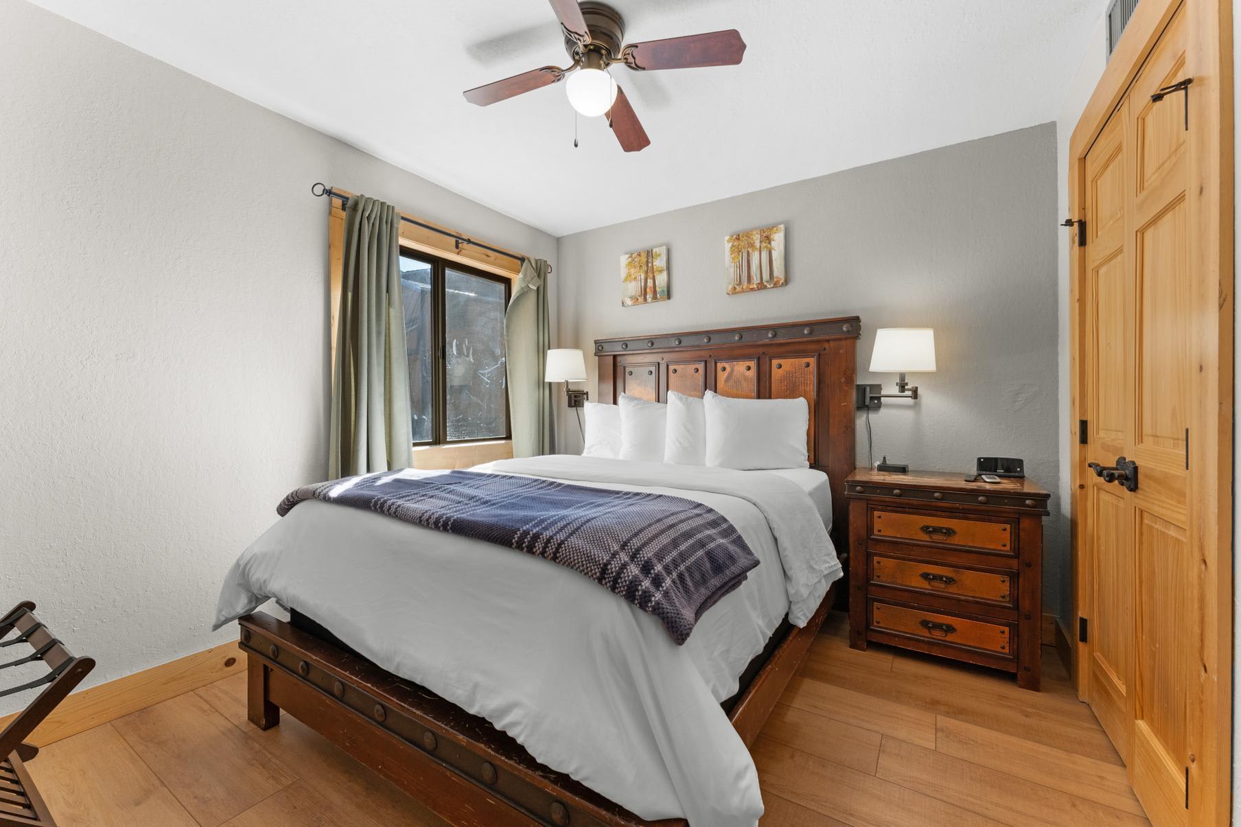 Cozy bedroom in a Truckee vacation rental featuring a wooden bed, soft linens, bedside tables, and natural light.