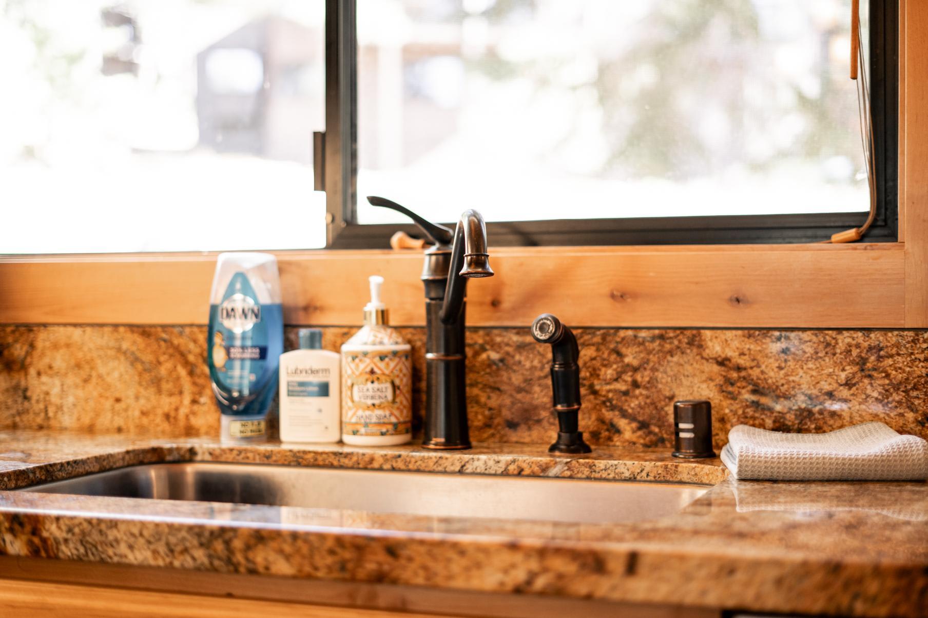 Granite kitchen sink in a Truckee vacation rental with soap and lotion bottles beside the faucet.