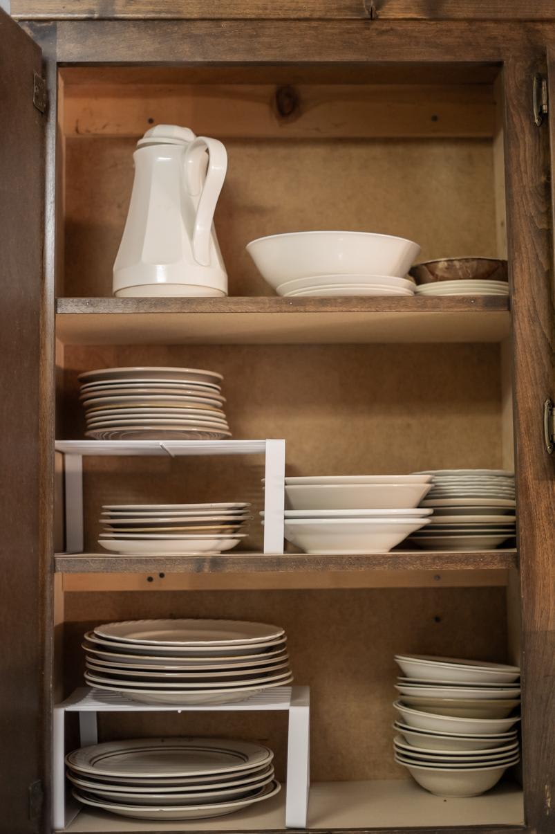 Cabinet with neatly stacked white dishes in a Truckee vacation rental kitchen.