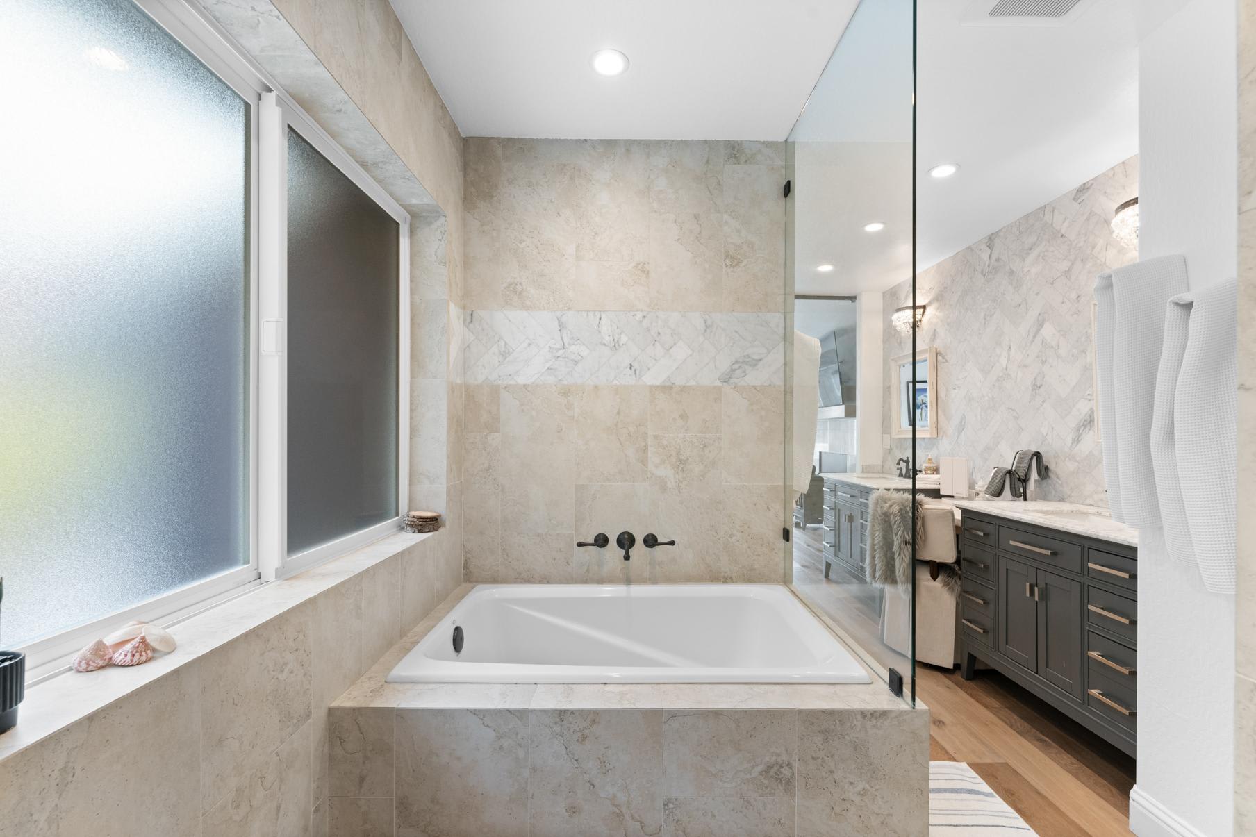 Luxurious bathroom in a Truckee vacation rental, featuring marble tiles, a spacious bathtub, and elegant vanity.