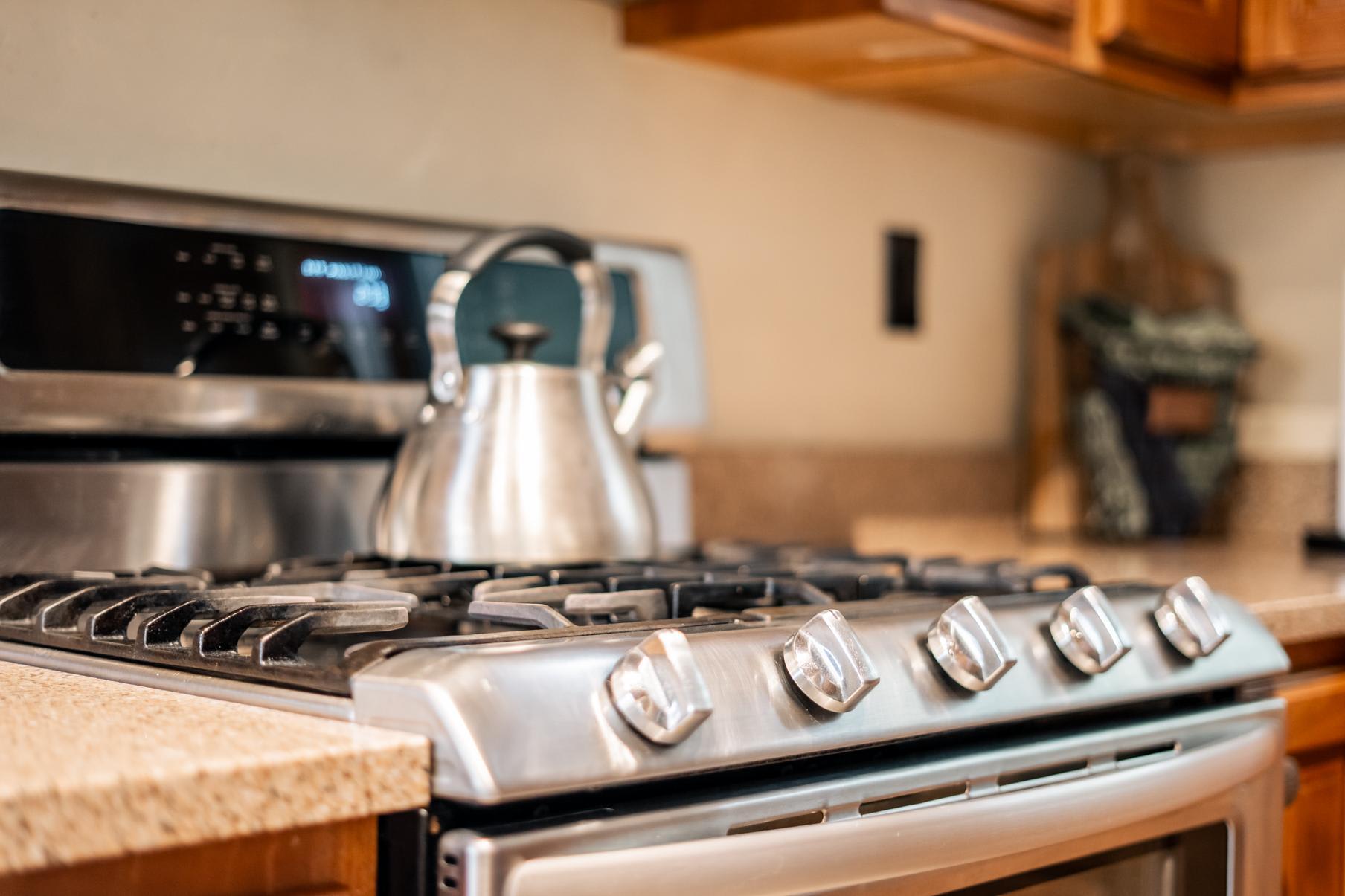 Stainless steel stove with kettle in a cozy kitchen of a Truckee vacation rental.