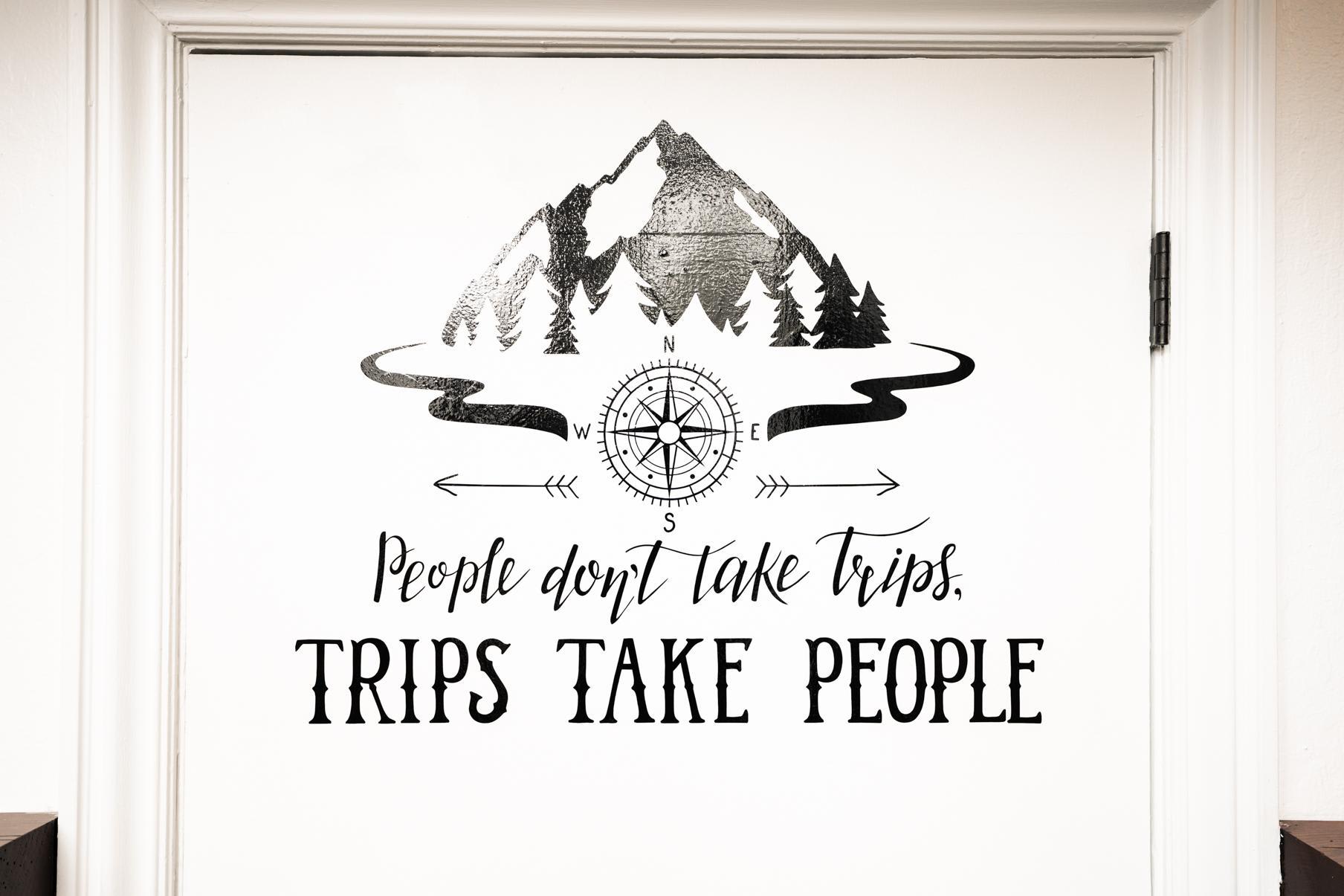 Wall art at a Truckee vacation rental: "People don't take trips, trips take people" with mountain and compass design.