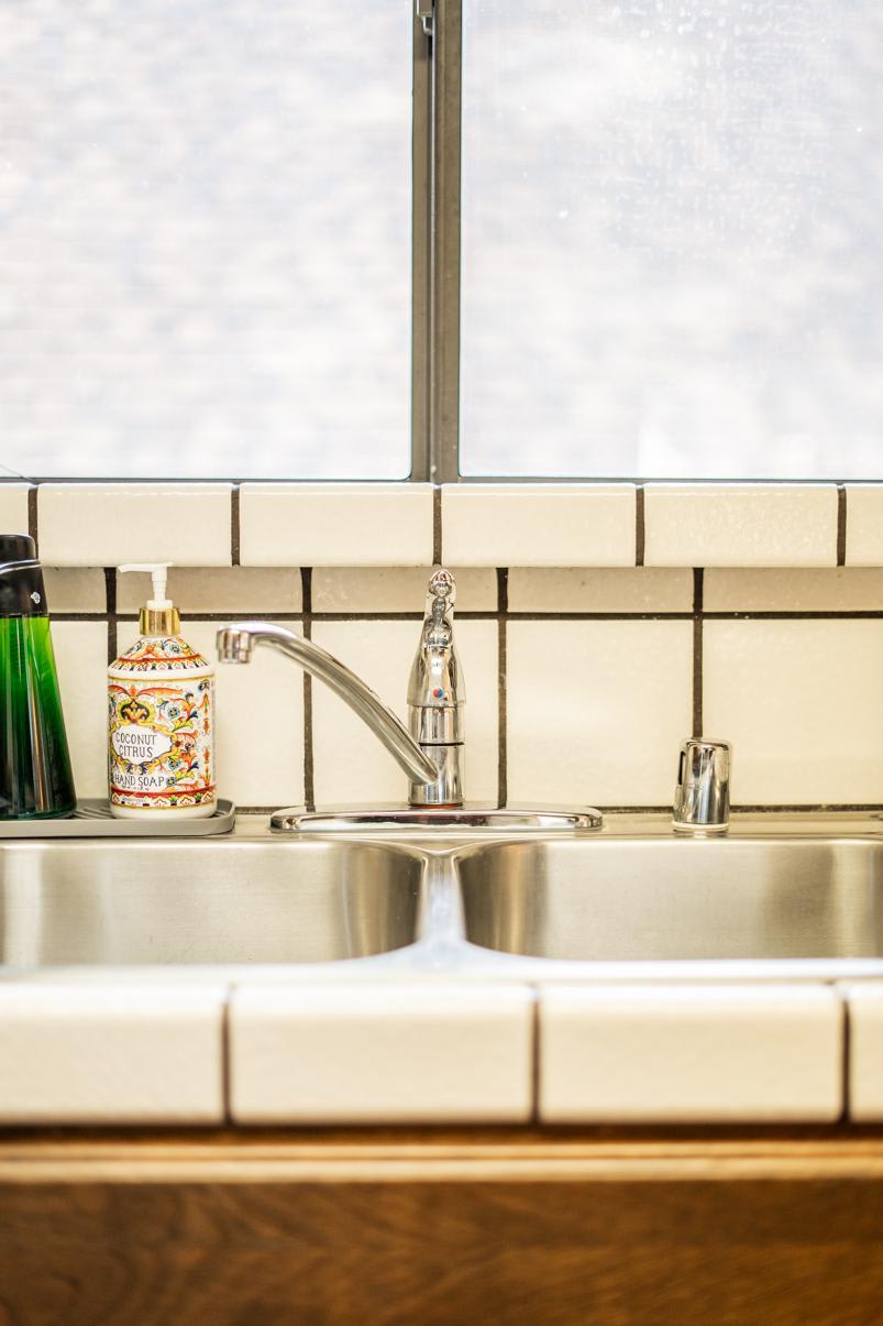 Kitchen sink with coconut citrus soap and green bottle in a Truckee vacation rental.