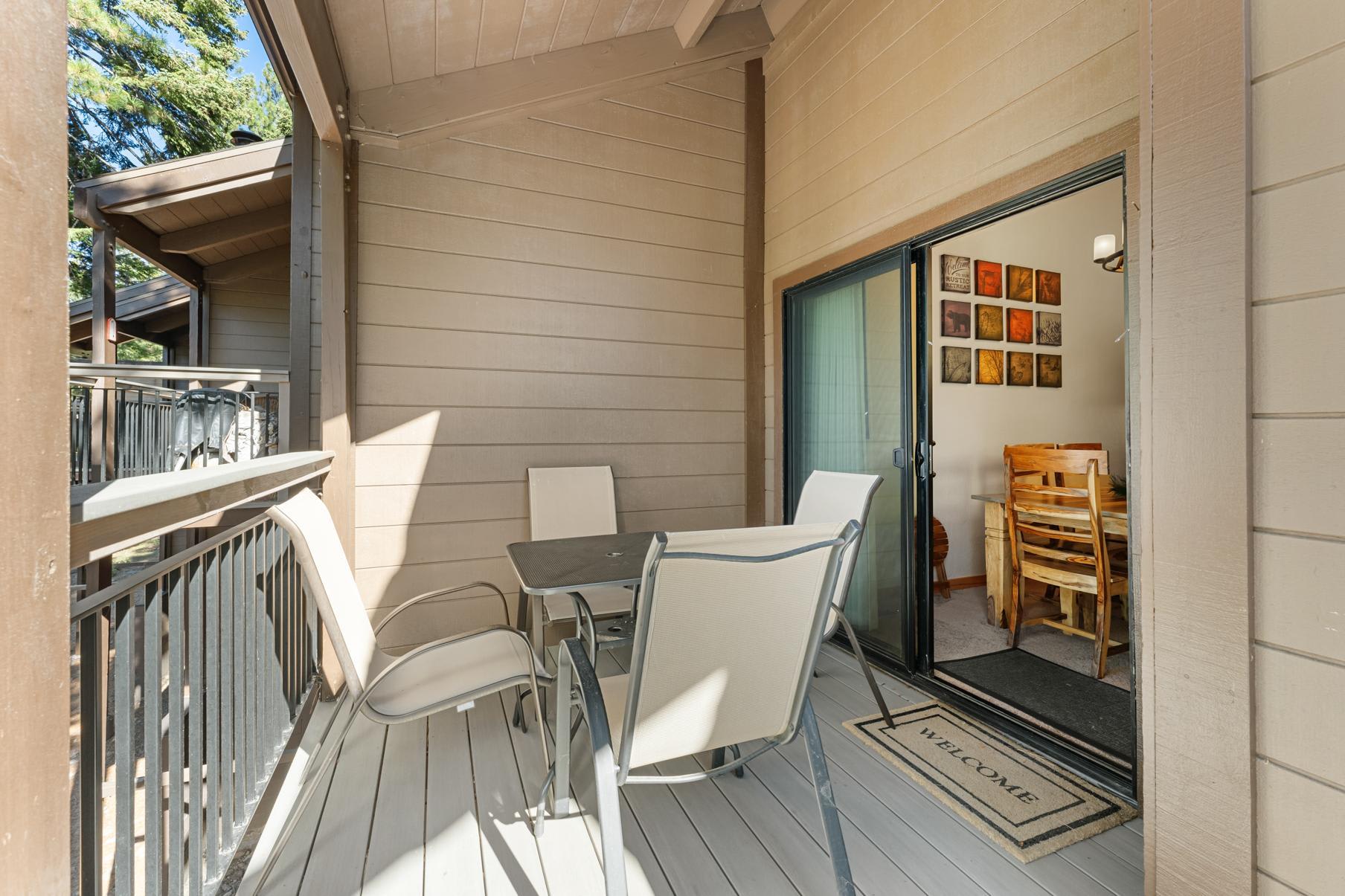 Cozy balcony in a Truckee vacation rental with outdoor seating and dining area, adjacent to an inviting interior space.