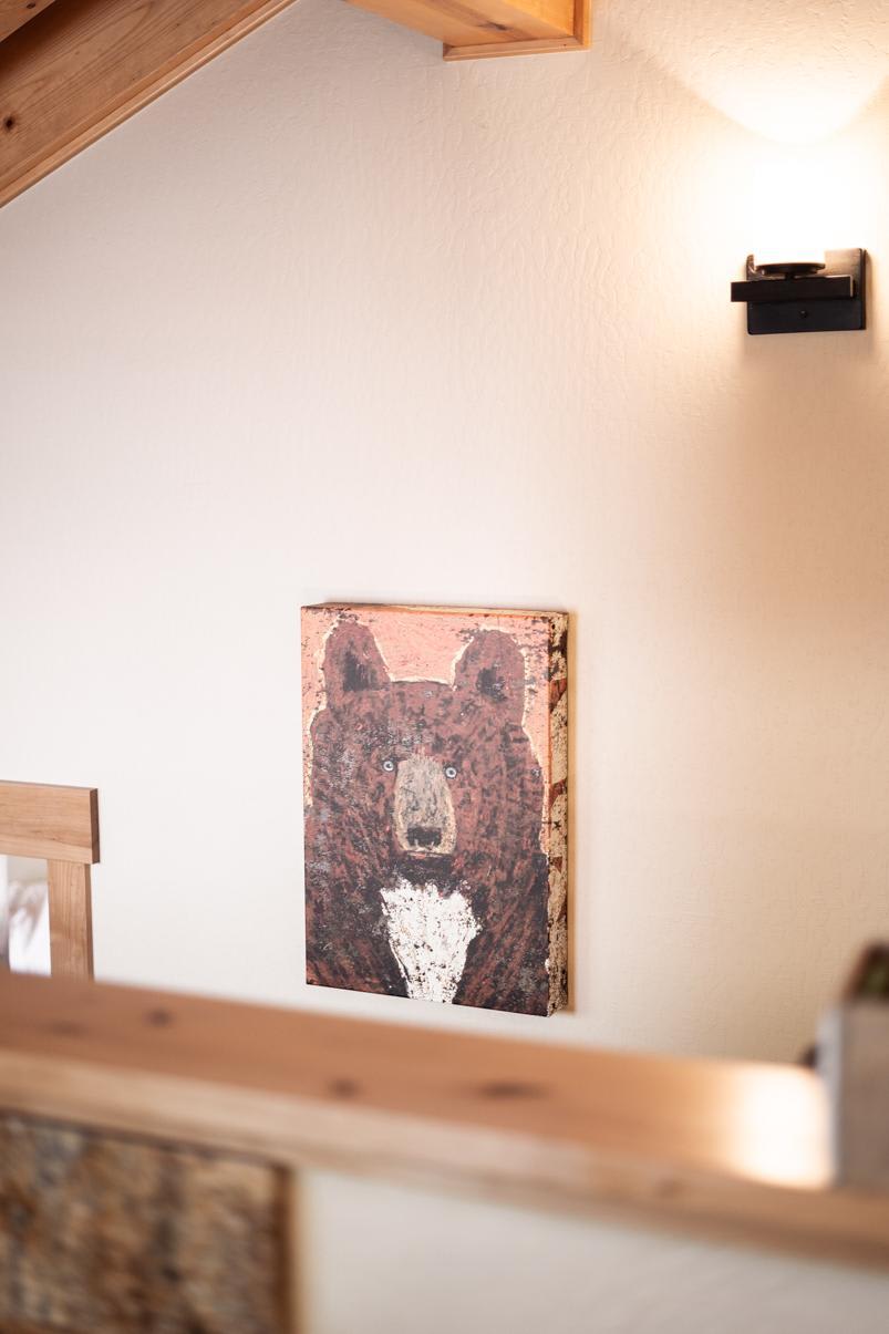 Bear painting on wall in a Truckee vacation rental, under warm lighting and exposed wooden beam ceiling.