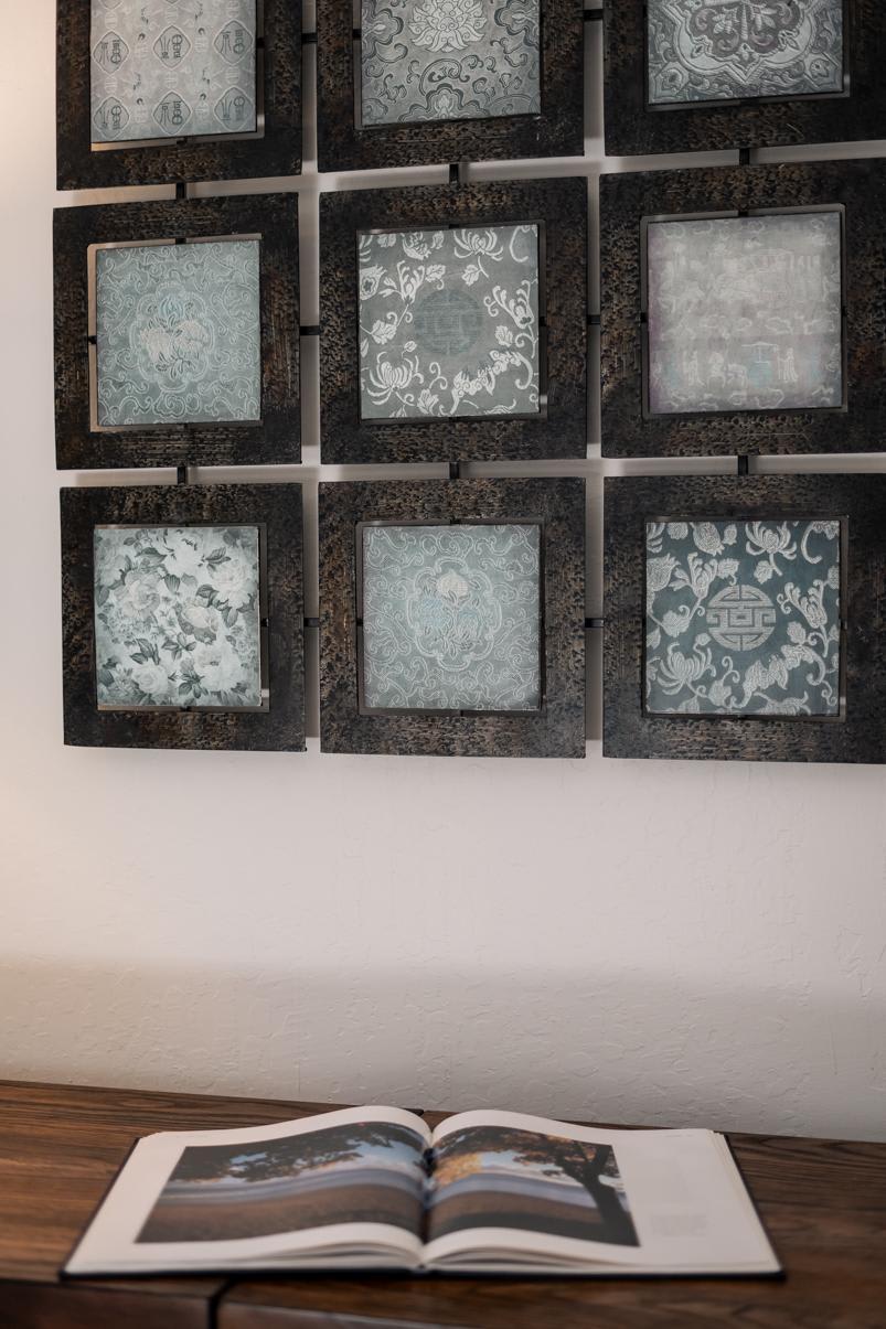 Wall art and open book in a Tahoe Vista vacation rental, featuring decorative square frames and wood surface.