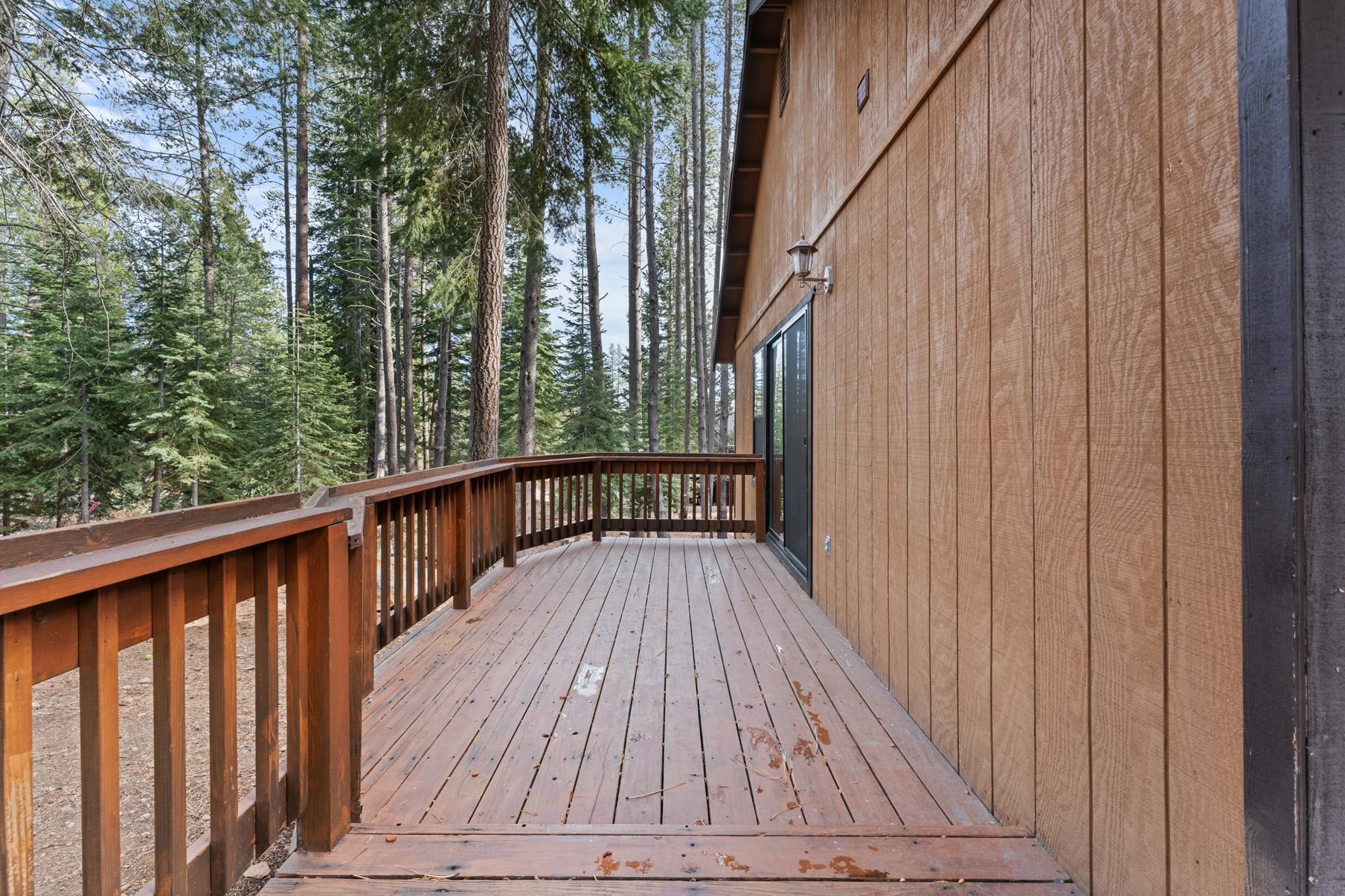 Wooden deck of a Truckee vacation rental surrounded by tall pine trees.