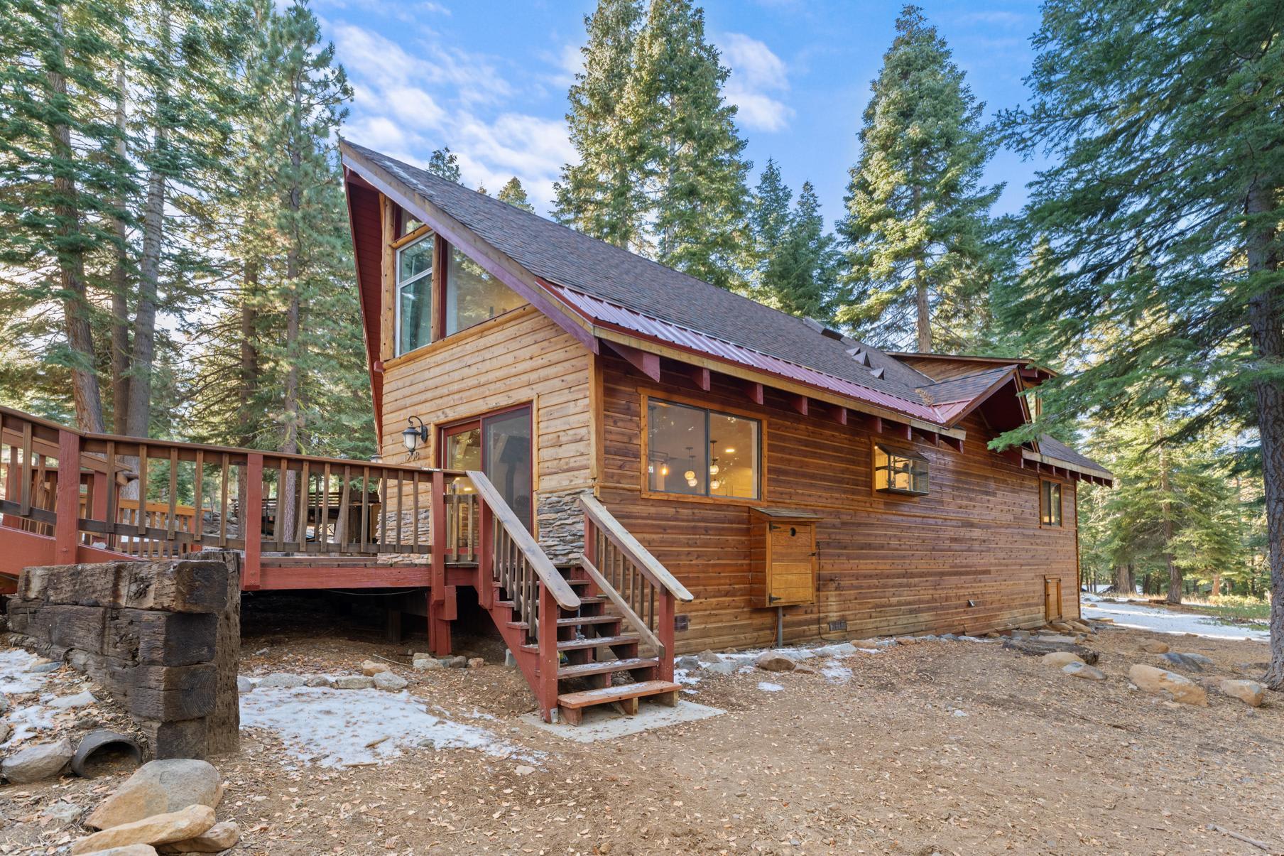 A-frame cabin in forested Tahoe Vista, perfect vacation rental with large windows and wooden deck.