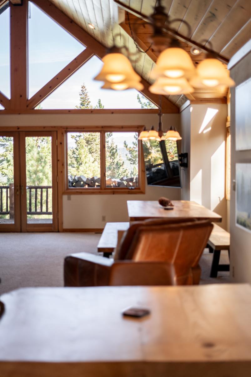 Cozy Truckee vacation rental with warm wood accents, large windows, and forest views from a spacious living area.